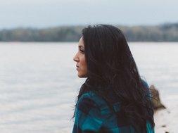 Angst- und Panikstörungen - Frau mit schwarzen Haaren, die aufs Wasser guckt
