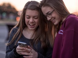 Depression: Zwei jugendliche Mädchen gucken auf ein Handy