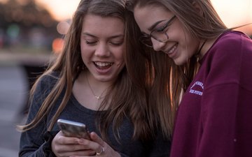 Depression: Zwei jugendliche Mädchen gucken auf ein Handy