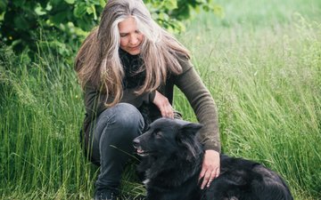 Artikel Borderline: Frau mit schwarzem Hund im Gras
