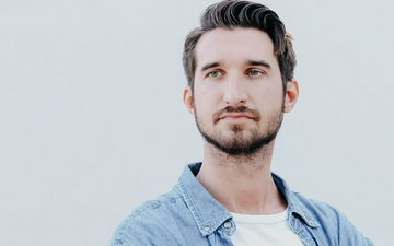 Artikel Therapie bei Depression: Mann vor grauem Hintergrund der traurig guckt