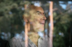 Mann hinter spiegelnder Fensterscheibe in Behandlungsraum