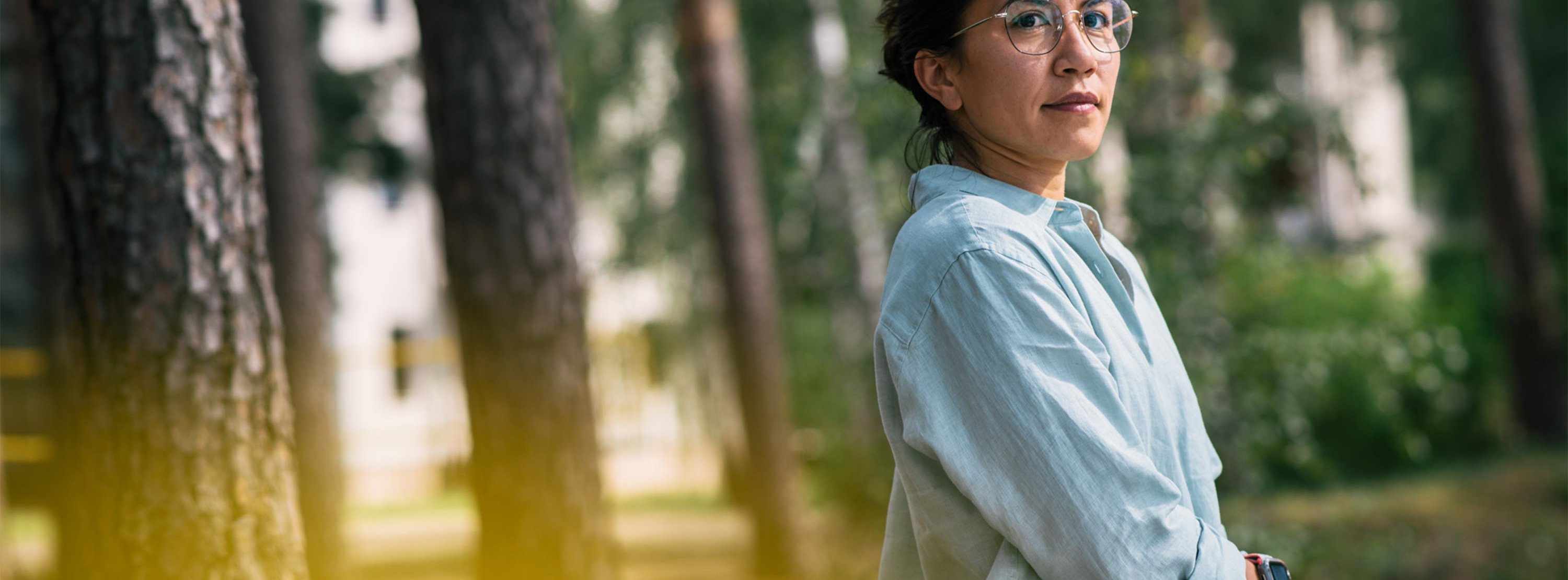 Eine Frau im Profil,  im Hintergrund Bäume: Therapie der Angststörung in heilsamer Umgebung