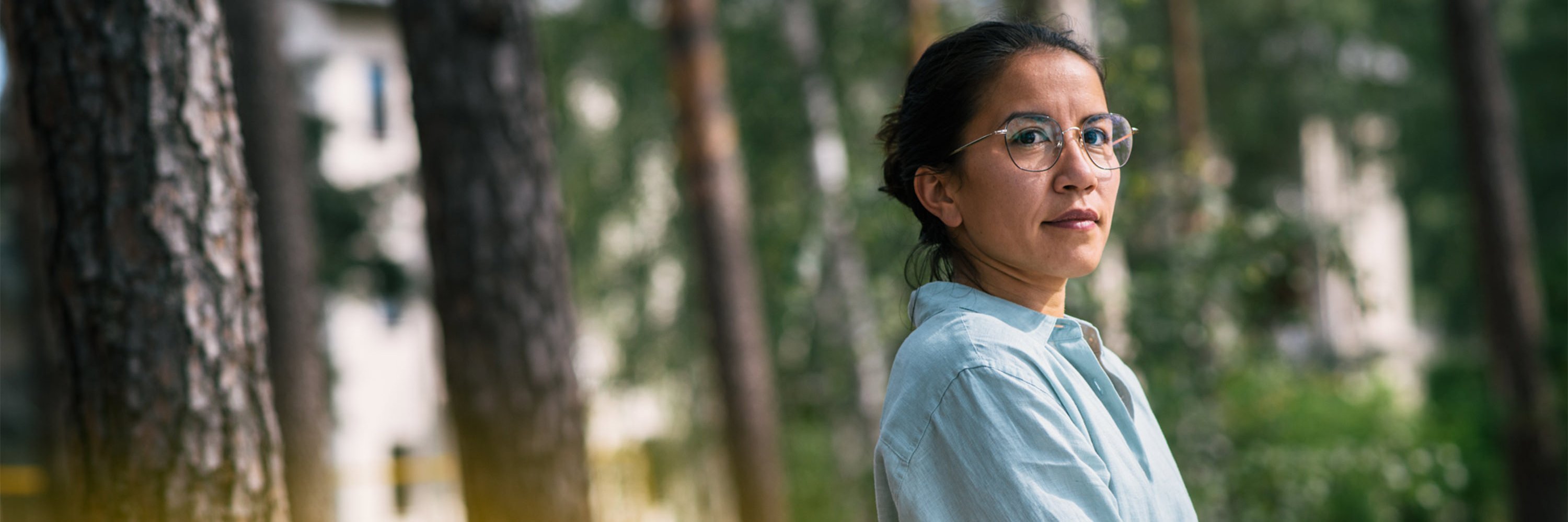 Eine Frau im Profil,  im Hintergrund Bäume: Therapie der Angststörung in heilsamer Umgebung