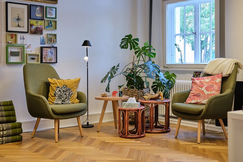 gemütliche Sitzecke mit grünen Sesseln und kleinen Tischen