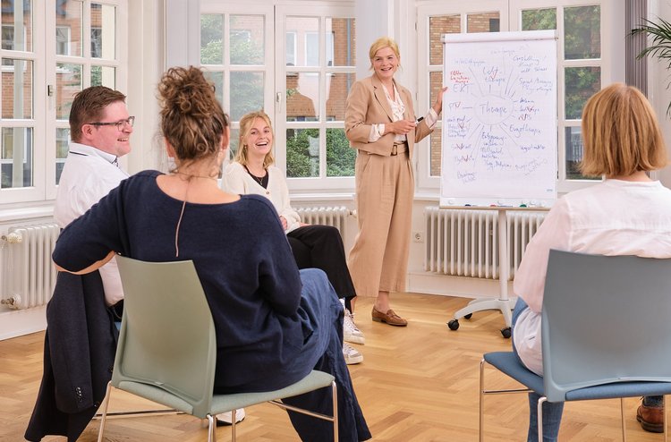 Gruppe von Ärzten und Therapeuten sitzt zusammen und tauscht sich aus