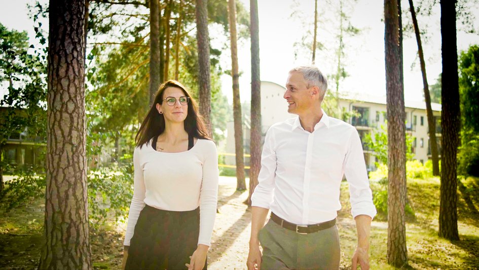 Gespräch zwischen 2 Personen die im grünen spazieren gehen