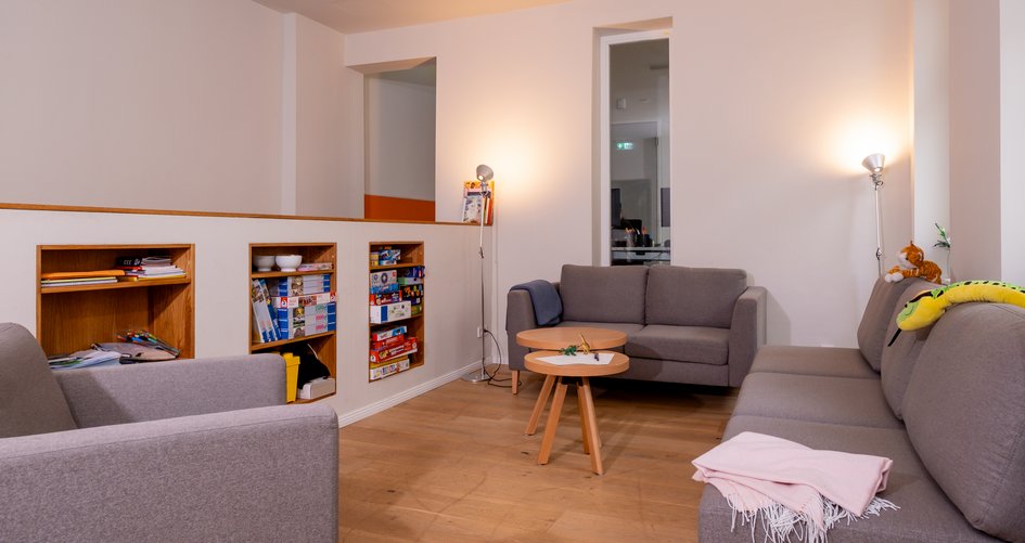 mehrere Sofas mit Regal voller Brettspiele