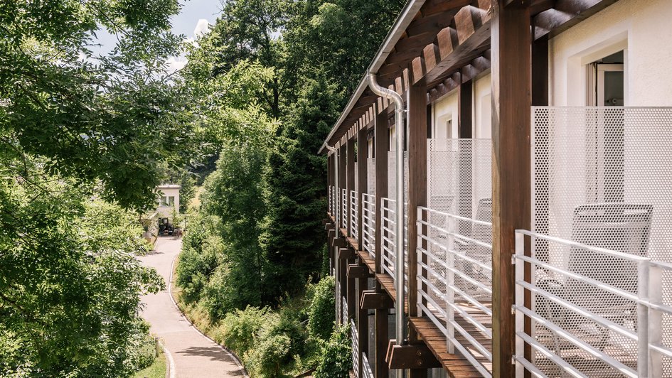 Die Fassade der Klinik, die direkt an Bäume und Sträucher grenzt. 