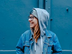 Artikel Essstörungen: Frau in blauen Klamotten vor einem blauen Hintergrund