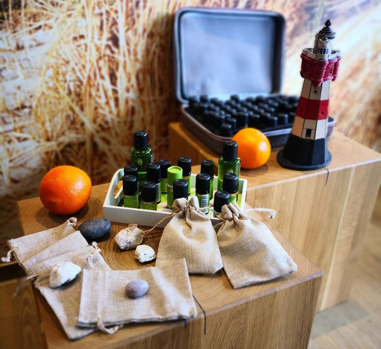 Aromatherapie Verschiedene Fläschchen, Orangen, Beutel und ein kleiner Leuchtturm