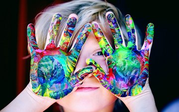 Artikel Autismus Kind mit farbigen Händen