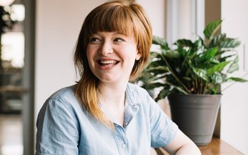 Fußballmuffel - Lächelnde Frau in blauem Oberteil