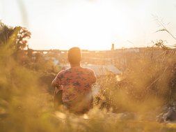 Trauma - Mann der in einem Feld sitzt
