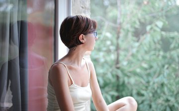 nachdenkliche Frau schaut aus Fenster