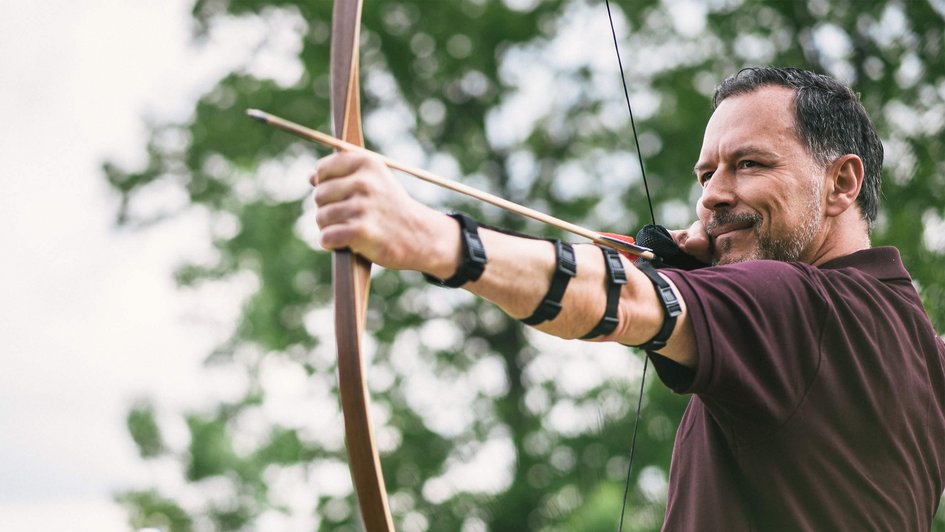 Mann beim Bogenschießen