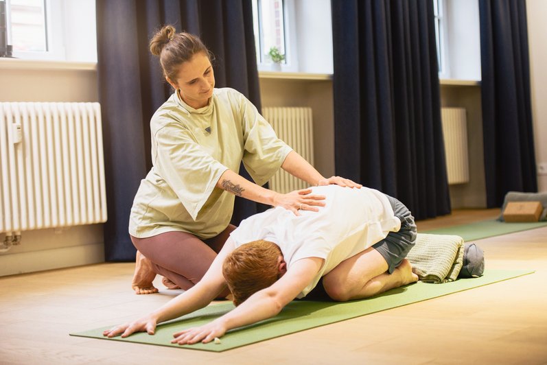 Patient macht unter Anleitung einer Therapeutin entspannendes Yoga