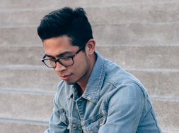 Trauma - Mann in blauer Jacke und mit schwarzer Brille