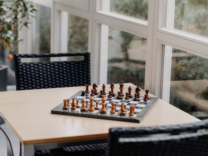 Schachbrett mit Figuren steht auf Tisch, bereit zum spielen