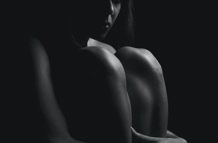 Artikel Folgen von Covid-19, Frau sitzt im Dunkeln