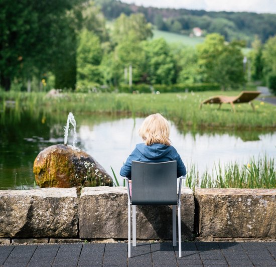 Artikel Frühkindlicher Autismus: Patient in einem Stuhl vor einem Brunnen