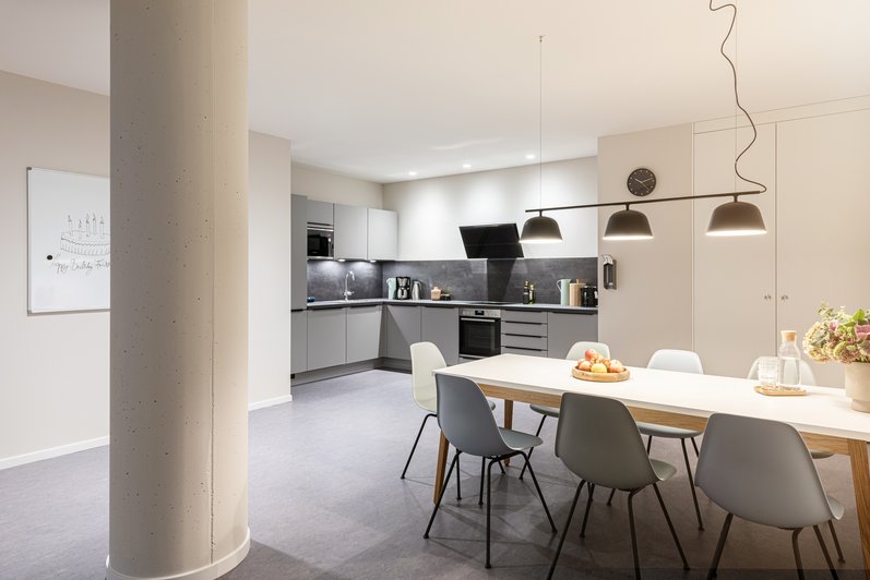 moderne Küche mit großem Esstisch, in einem hellen gut beleuchteten Ambiente