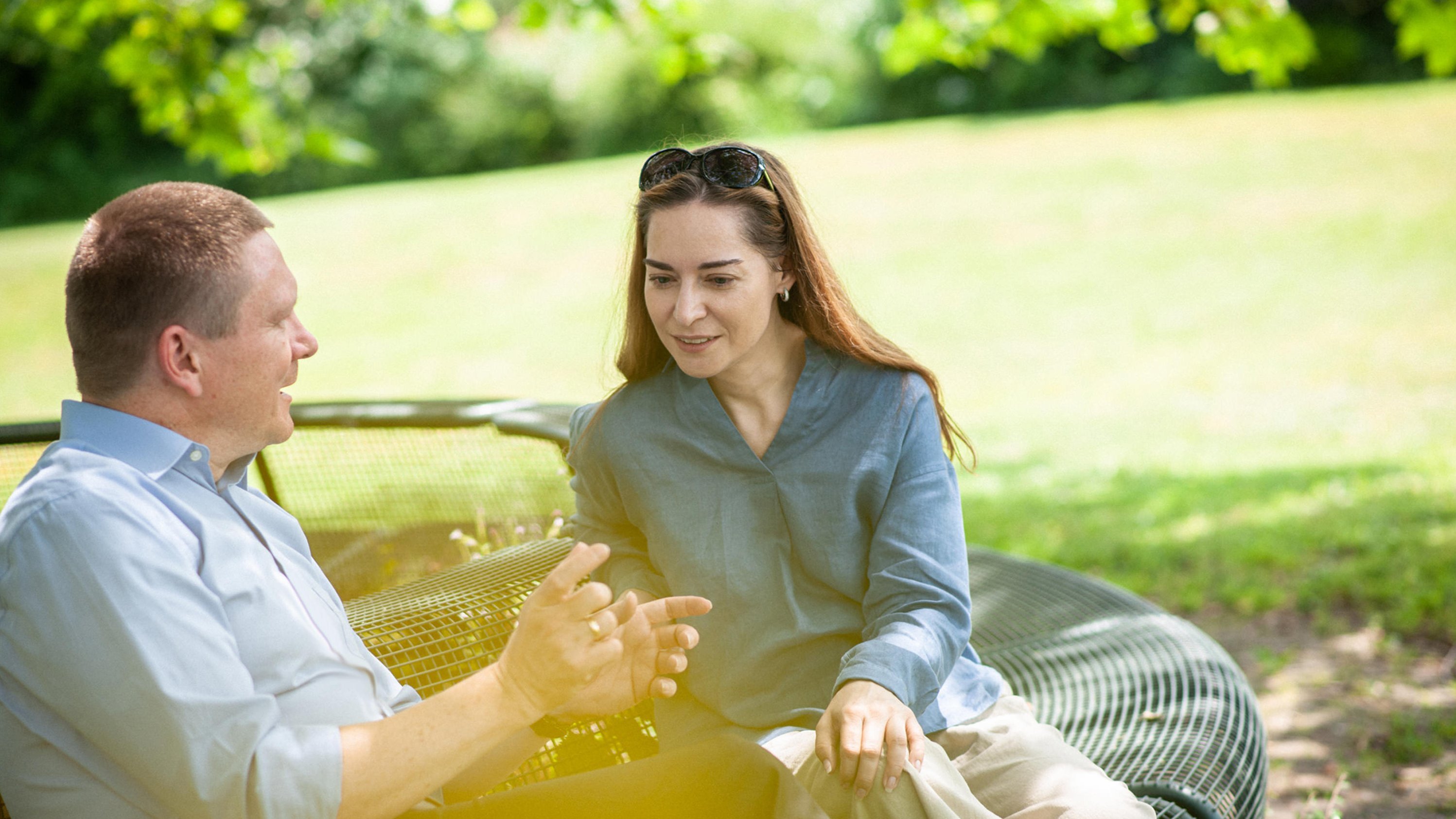 Patientin im Gespräch mit ihrem Therapeuten auf grüner Wiese