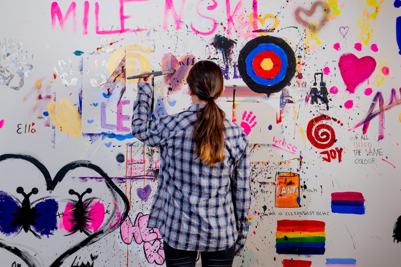 Patientin malt an großer Kunstwand