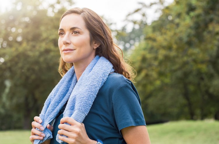 Artikel Resilienz: Frau mit Handtuch im Wald