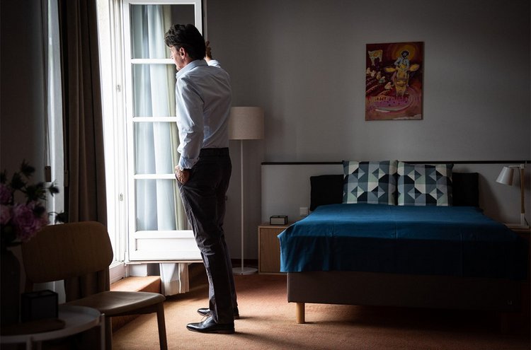 Artikel Resilienz: Mann steht vor einem Fenster in einem dunklen Raum