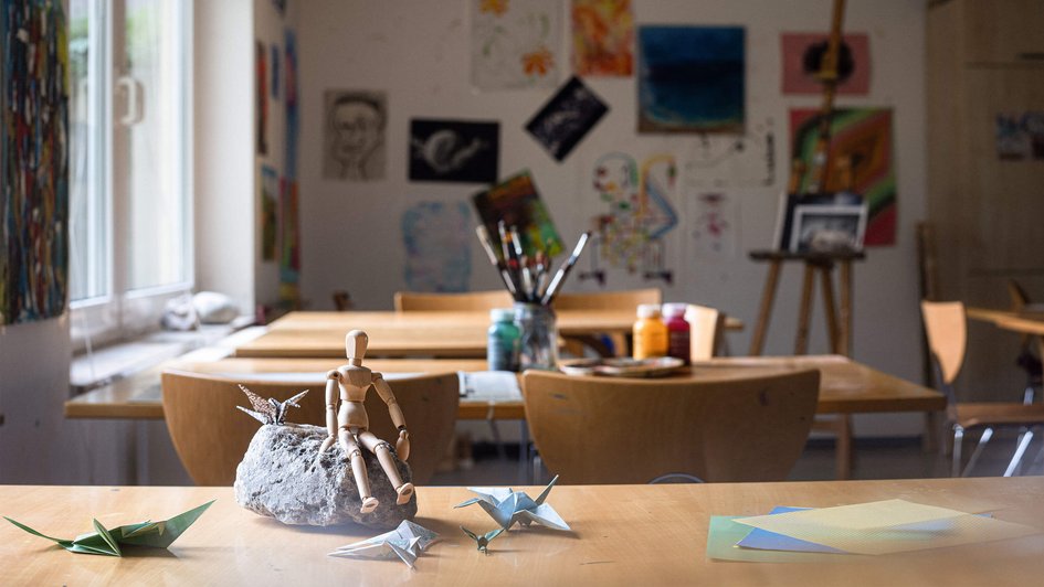 Holzpuppe auf Stein in einem Kunstraum