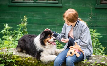 Artikel Persönlichkeitsstörungen: Frau mit Hund vor grünem Haus