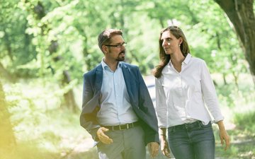 In der Natur findet ein Therapiegespräch zur Behandlung Somatoformer Störungen statt, Bäume und grüne Blätter im Hintergrund