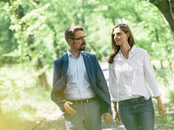 In der Natur findet ein Therapiegespräch zur Behandlung Somatoformer Störungen statt, Bäume und grüne Blätter im Hintergrund