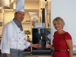 Artikel Trinkwasserspender: Koch und Frau vor einem Trinkwasserspender